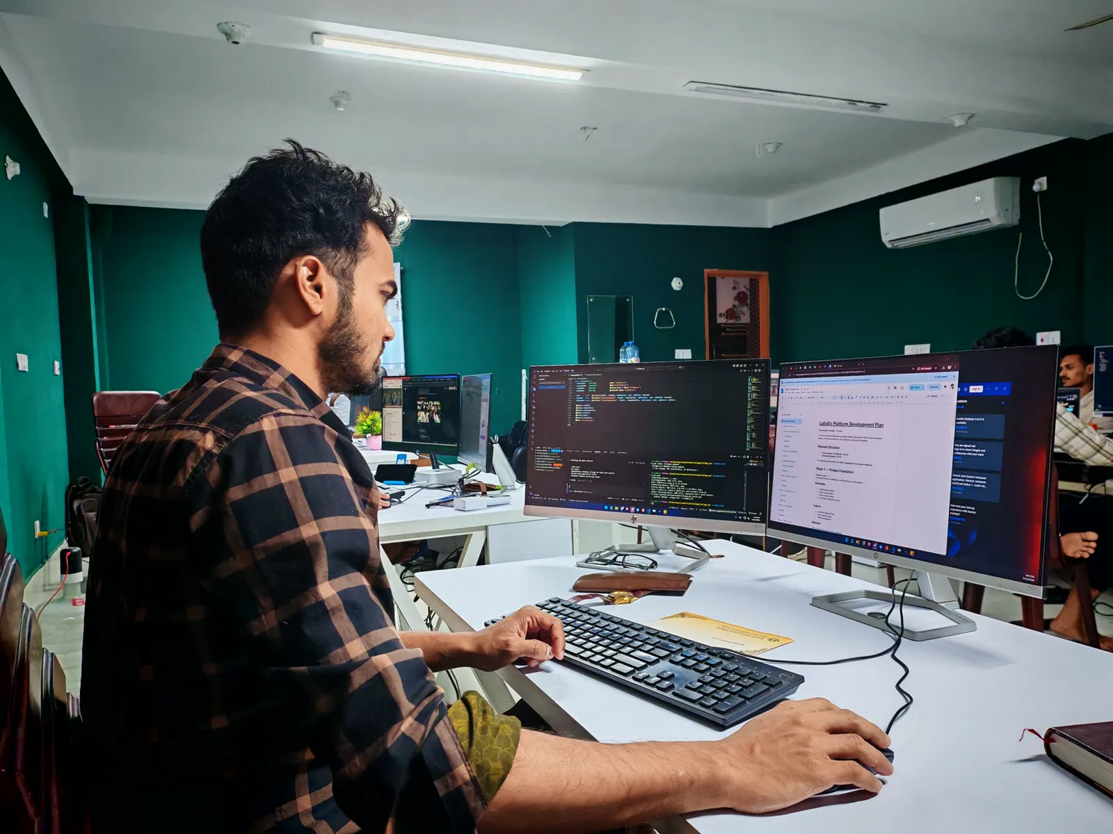 Desenvolvedor trabalhando em um sistema com múltiplos monitores